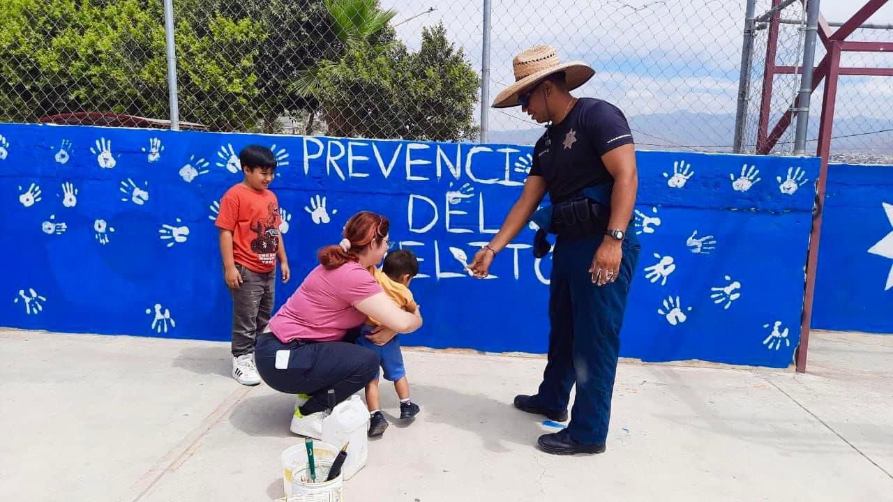 Policías municipales y niños plasman arte en mural preventivo